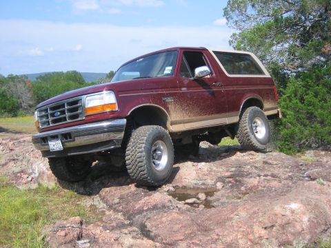 1996 Ford Bronco - This 1996 Ford Bronco is shown navigating a challenging rocky landscape, highlighting its off-road capabilities.