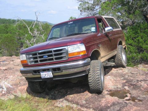 1996 Ford Bronco - This 1996 Ford Bronco is navigating a rocky terrain with its tires angled on the uneven surface.