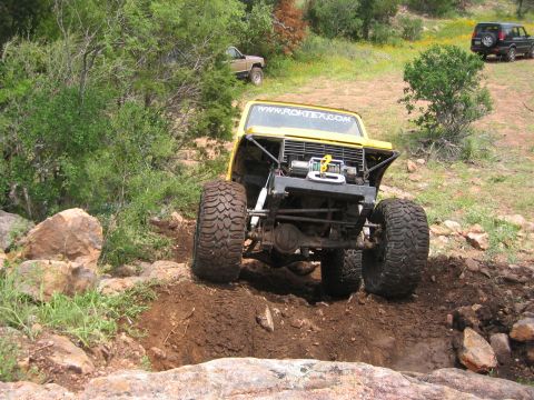 1996 Ford Bronco - 1996 Ford Bronco tackling an off-road obstacle with a second vehicle visible in the background.