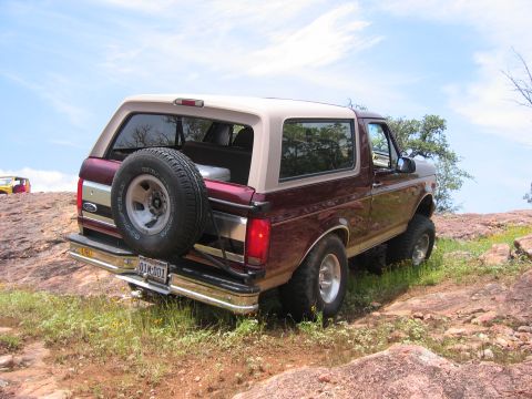 1996 Ford Bronco - 1996 Ford Bronco on a rocky trail under a blue sky. A second vehicle is visible in the background.