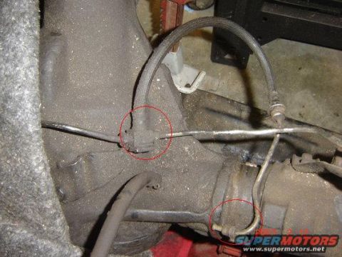 1992 Ford Bronco - Close-up view of a vehicle's rear axle brake line junction, with specific connection points circled in red.