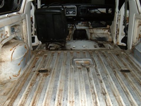 1978 Ford Bronco - The interior of the vehicle is stripped down, revealing the ribbed metal floor and dashboard.
