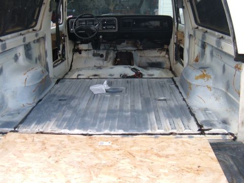 1978 Ford Bronco - The interior of a 1978 Ford Bronco is shown stripped down, ready for a redo, with exposed metal flooring and dashboard visible.