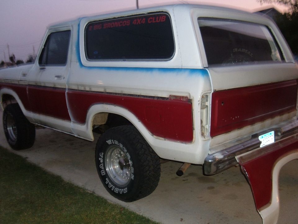 Two-tone red and white lifted Ford Bronco rear three-quarter view