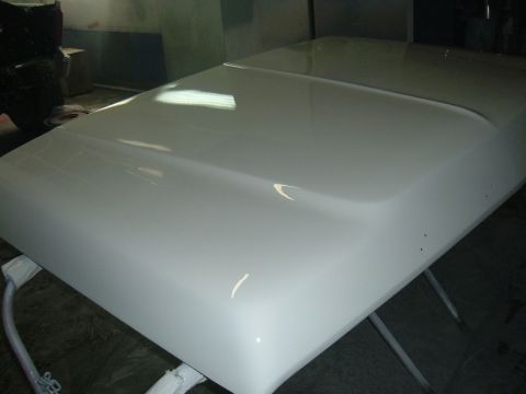 1978 Ford Bronco - A freshly painted vehicle hood is shown in a workshop setting.