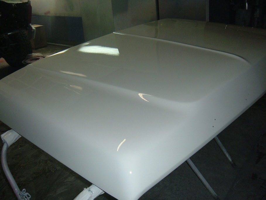 White vehicle hood on sawhorses, freshly painted
