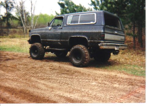 1990 Chevrolet Blazer - Modified 1991 Chevrolet K5 Blazer with large tires parked on a muddy trail.
