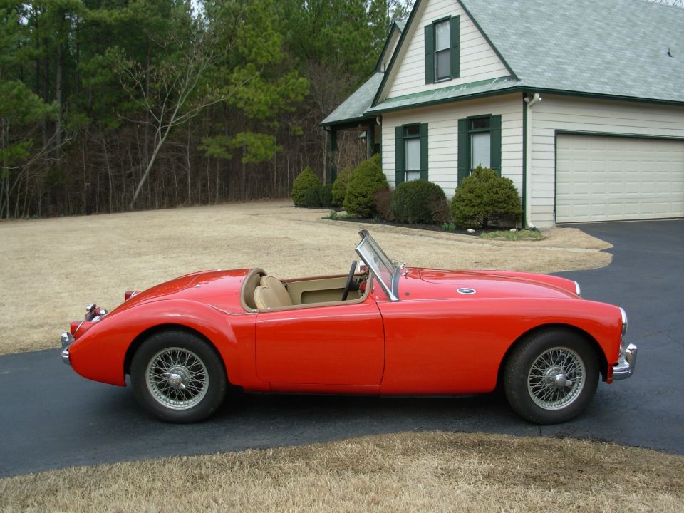 Red 1959 MG A convertible parked in front of a house