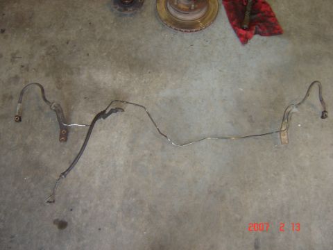 1993 Ford Bronco - Brake lines are laid out on a concrete surface, with automotive parts visible in the background.