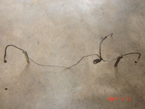 1993 Ford Bronco - This is a brake line assembly, likely for an older vehicle, lying on a concrete surface.