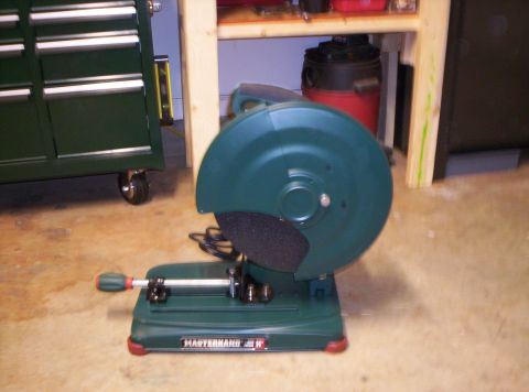 1995 Ford Bronco - A green chop saw is positioned on a concrete floor, with a tool chest visible to the left.