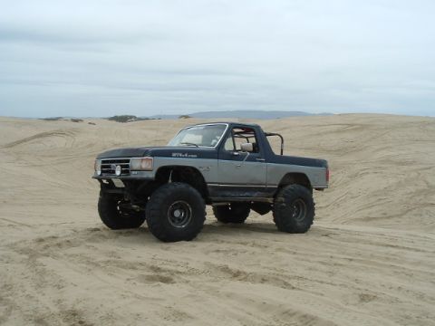 1989 Ford Bronco - This modified SUV is seen on sand dunes, with a two-tone paint job and oversized tires.