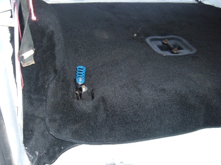 1978 Ford Bronco - Close-up of the interior carpet, showing a blue spring mechanism and a metal latch.