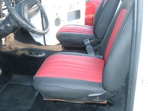 1978 Ford Bronco - The interior of a vehicle features two-tone red and black seats and a black carpeted floor.