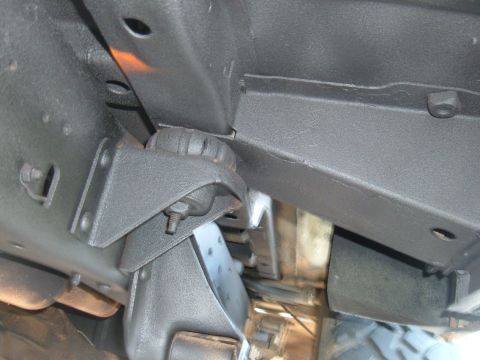 1978 Ford Bronco - Close-up view of the underbody coating on a vehicle's frame, showing structural components and mounting hardware.