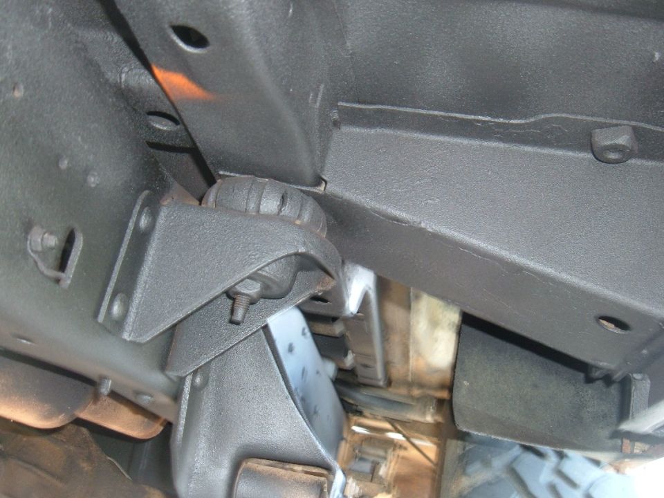 Underbody coating on vehicle frame with visible mounting bracket