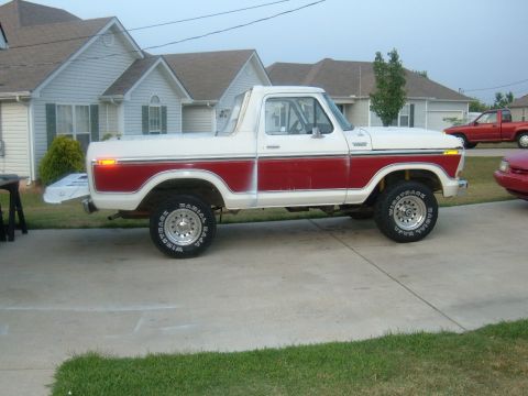 1978 Ford Bronco - A two-tone 1978 Ford Bronco is parked in a driveway next to a red car and a red pickup truck.