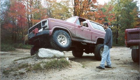 1980 Ford Bronco - A maroon 1980 Ford Bronco navigates an obstacle course, with another vehicle visible to the right.