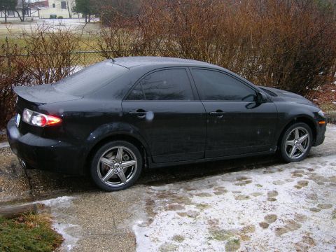 1994 Ford Probe - A black sedan is parked on a driveway with patches of snow and ice.