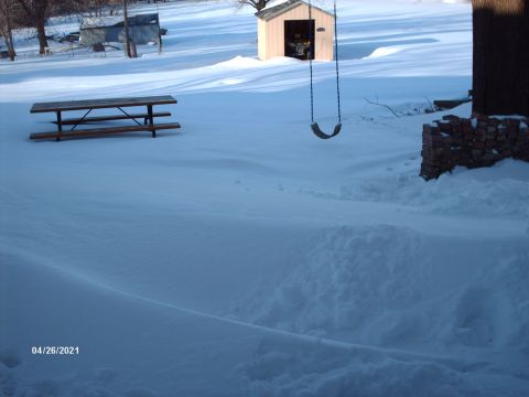 1995 Ford Probe - A snowy scene with a picnic table and a swing set in the yard.