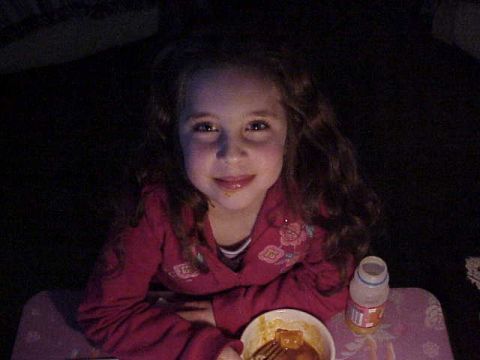1993 Ford Bronco - A young girl with curly hair smiles while eating from a bowl at a table.
