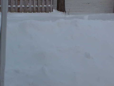 1993 Ford Bronco - A winter scene with deep snow covering the ground, a wooden fence, and a tree.