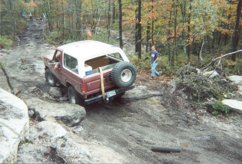 1980 Ford Bronco - This 1980 Ford Bronco is tackling a challenging off-road course in a wooded area.