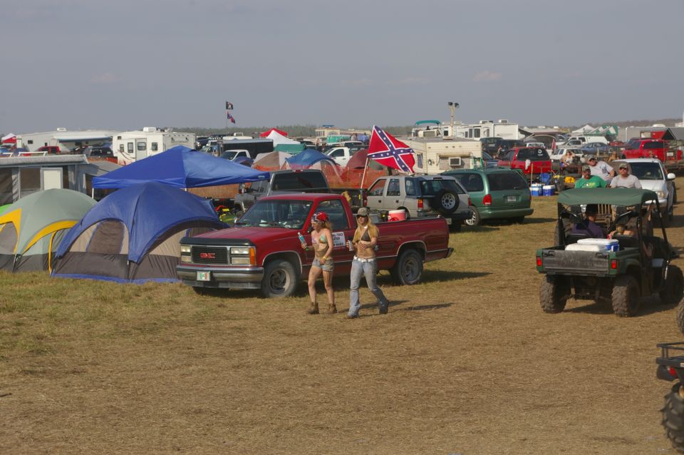 Red GMC pickup truck with a Confederate flag visible in the background