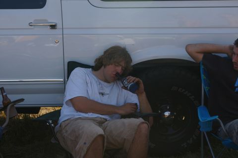 1974 Ford F-100 - Two men relax near a white van, one drinking from a bottle.