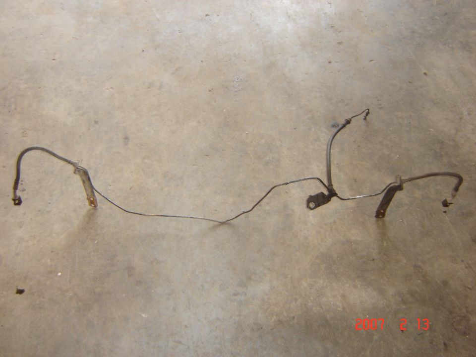 Brake line assembly with two mounting brackets on a concrete floor