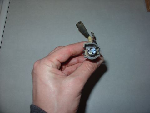 1988 Ford Bronco - A hand holds an electrical connector, which appears to be a vehicle part, against a plain background.