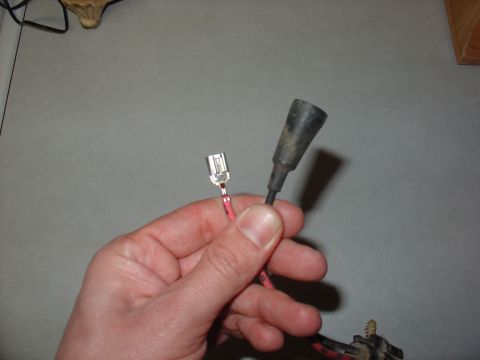 1988 Ford Bronco - Hand holds a female spade connector and a black rubber boot for an electrical connector.
