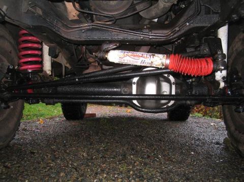 1979 Ford Bronco - Undercarriage view shows red coil springs and a Skyjacker Hydro steering stabilizer, suggesting aftermarket modifications.