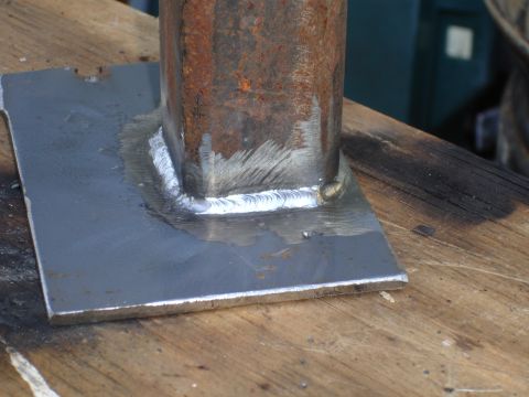 1989 Ford Bronco - A close-up view of a metal bracket that has been welded, showing the junction between a square tube and a flat plate.