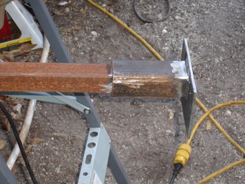 1989 Ford Bronco - A close-up view of a metal part being welded and resting on a stand.