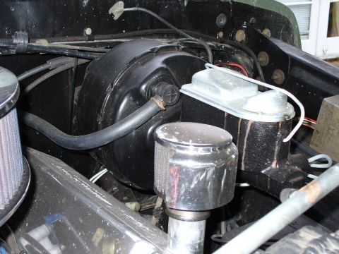 1978 Ford Bronco - Close-up view of the brake booster and master cylinder assembly within a vehicle's engine compartment.