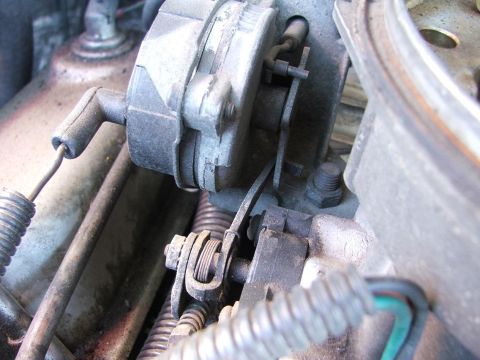 1985 Ford Crown Victoria LTD - Close-up view of a vehicle's throttle body mechanism and associated linkages.