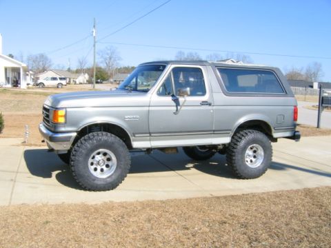 1989 Ford Bronco - Silver 1989 Ford Bronco with aftermarket wheels and tires parked on a driveway.