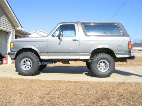 1989 Ford Bronco - This lifted 1989 Ford Bronco is shown in a side profile, oversized off-road tires and a two-tone paint scheme.