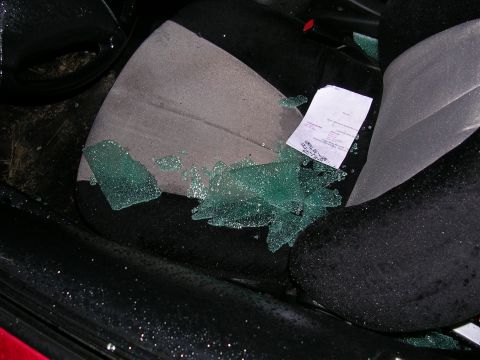 1996 Ford Probe - The interior of a car shows shattered glass on the seat, likely from a break-in.