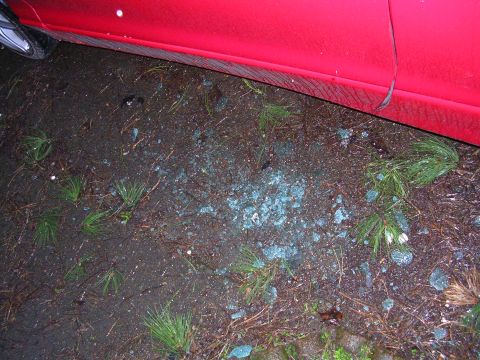 1996 Ford Probe - Shattered glass litters the ground next to a red car door, suggesting a break-in.