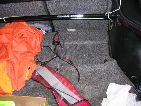 1996 Ford Probe - The trunk of a vehicle contains an orange tarp, a red bag, and loose wiring.