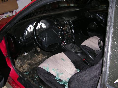 1996 Ford Probe - The interior of a red 1996 Ford Probe shows shattered glass on the passenger seat and floor.