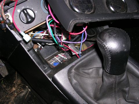 1996 Ford Probe - The interior of a car reveals a mess of wires and a gear shift knob, suggesting a break-in or modification.