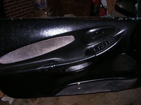 1996 Ford Probe - Close-up of a car's interior door panel, showing the handle and speaker area.