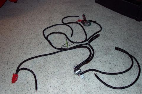 1991 Ford Bronco - A complex vehicle wiring harness is spread out on a carpeted floor, showing various connectors and bundles of wires.