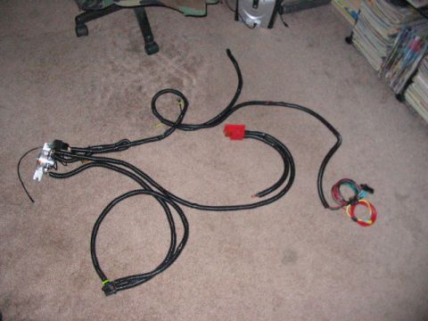 1991 Ford Bronco - A complex wiring harness lies on a carpeted floor, showing various connectors and bundles of wires.