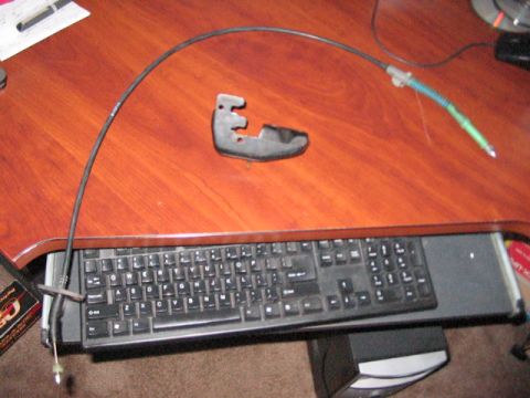 1991 Ford Bronco - Throttle cable and bracket on a desk. The album claims it's from a 1991 Ford Bronco.
