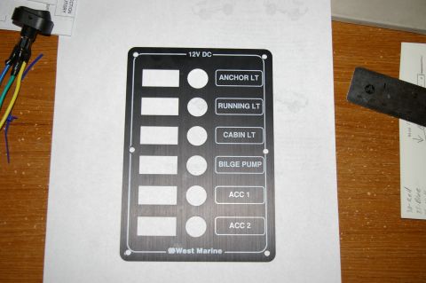 1986 Ford Bronco - A marine electrical switch panel with multiple labeled buttons and indicator light cutouts is shown on a wooden surface.