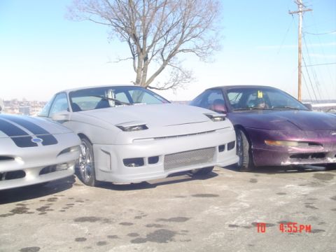 1995 Ford Probe - Three coupes are parked side-by-side under a clear sky.